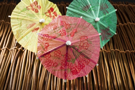 Colorful cocktail umbrellas on wooden base. Close up の写真素材