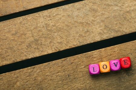 Word love on multicolored wooden cubes on wooden backgroundの写真素材