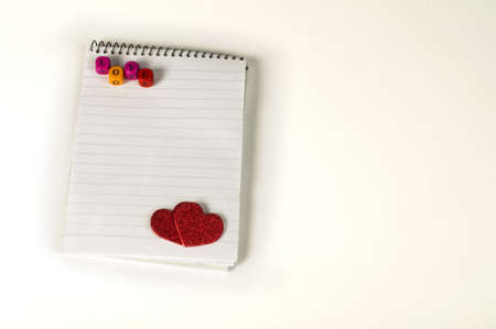 Red hearts and white paper sheet on white backgroundの写真素材