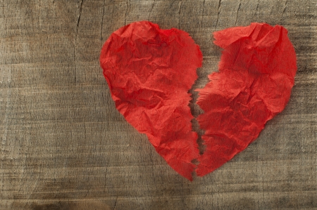 Heartbreak made ââof curled red paper on wooden boardの写真素材