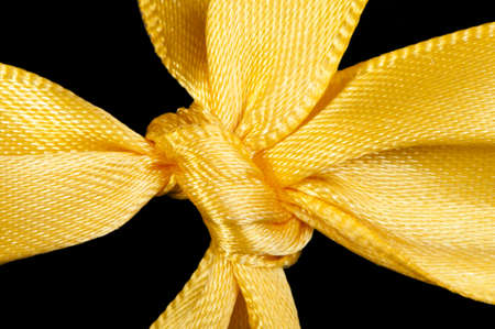 Yellow ribbon and knot isolated. Close up studio shot.の写真素材