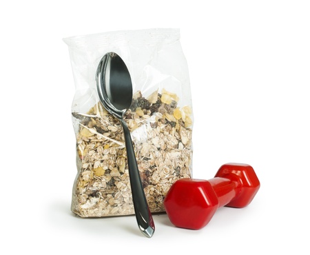 Muesli breakfast in transparent package.Spoon and dumbbell white isolatedの写真素材