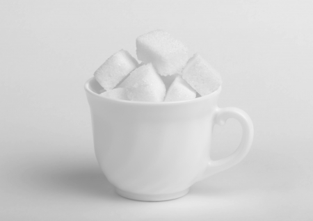 Sugar lumps in cup on white backgroundの写真素材