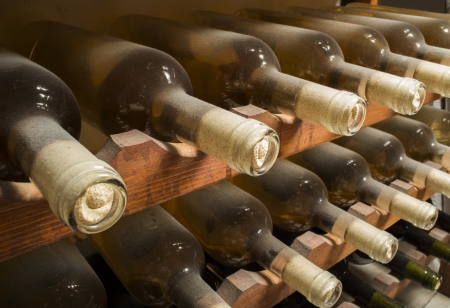 Wine bottles on shelf. Wine cellar. Close up wine bottles.