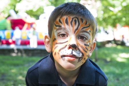 Child with painted face. Tiger paint. Boy on children's holidayの写真素材