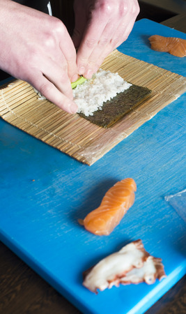 Sushi in sushi bar. Sushi making.Hands rolling sushiの写真素材