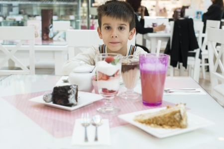 Cake and a milkshake in confectionery. Child on a tableの写真素材