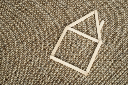 Model house made of wooden sticks placed in room interior.の写真素材