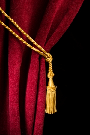 Red velvet curtain with tassel. Close up black isolated curtainの写真素材