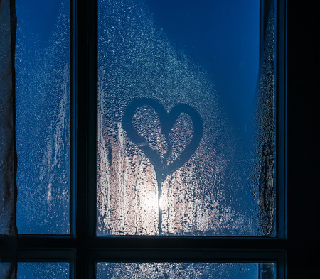 Moonlight through the window. Sweaty glass and heart shapeの写真素材