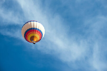 Multicolored Balloon in the blue cloudy skyの写真素材
