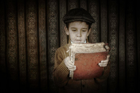Child with red vintage book. Vintage clothes and hatの写真素材