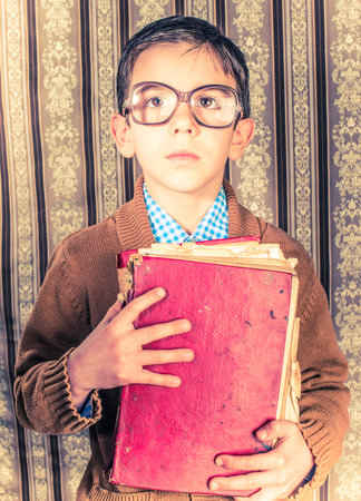 Child with glasses hold red vintage book. Vintage clothesの写真素材