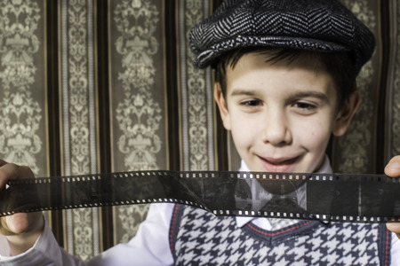 Child considered analog photographic film. Vintage clothes and background