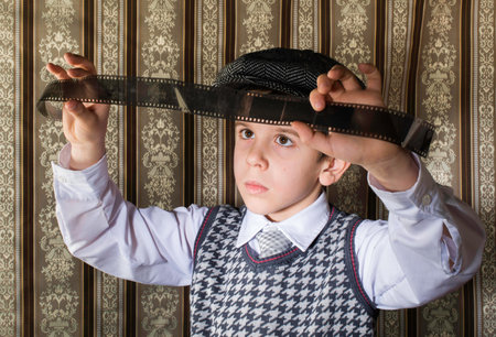 Child considered analog photographic film. Vintage clothes and backgroundの写真素材