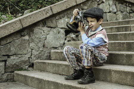 Child with vintage camera. Exterior stairsの写真素材