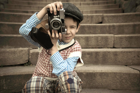 Child with vintage camera. Exterior stairs