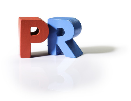 Multicolored text PR made of wood. White background Multicolored text PR made of wood. White background