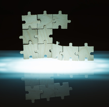 Wooden puzzle and backlight background. Vertically stacked parts.