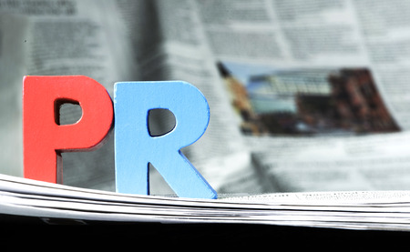 Word PR on newspaper. Wooden letters Word PR on newspaper. Wooden letters