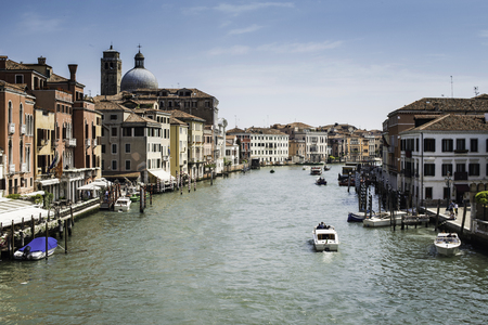 Ancient buildings and boats in the channel in Venice.の写真素材