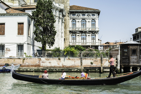 Ancient buildings and boats in the channel in Venice. Gondolierの写真素材
