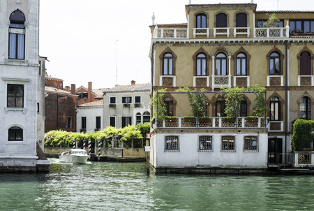 Ancient buildings in Venice. Boats moored in the channel. View from the side of the waterの写真素材