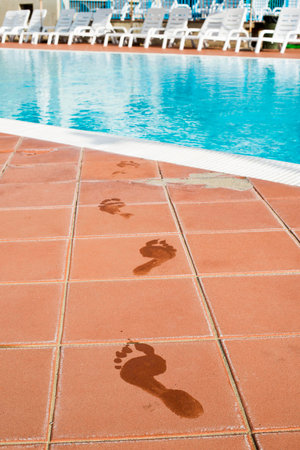 Footprints of bare feet to swimming pool. Water footprintsの写真素材