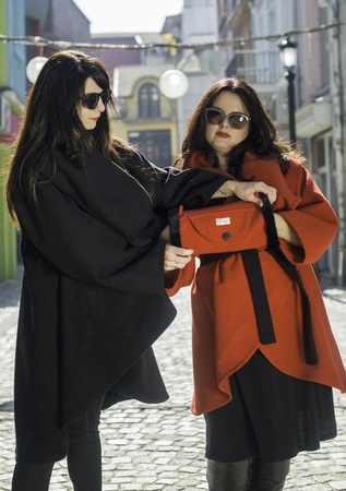 Two women in jackets on a street. Sunlightのeditorial素材
