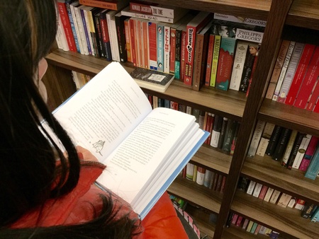 Women unfold book in a bookstore