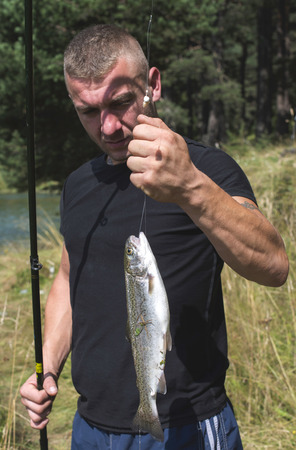 Fisherman caught a fish in mountain dam. Bulgariaの写真素材