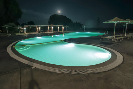 Pool, sunbeds and umbrellas at night. Night lights. Greece, Gythioのeditorial素材