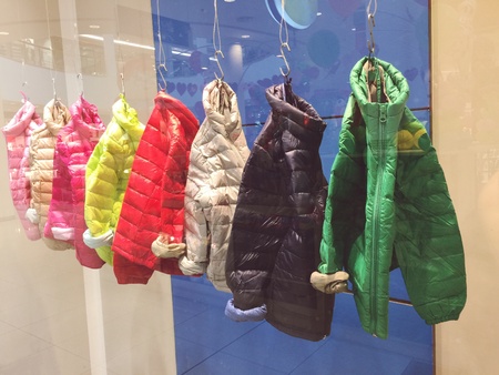 Multicolored kids jackets on a showcaseの素材