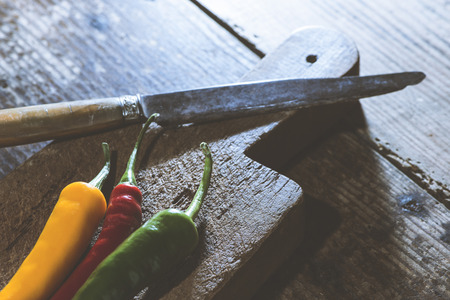 Hot peppers on wooden kitchen cutting boardの写真素材