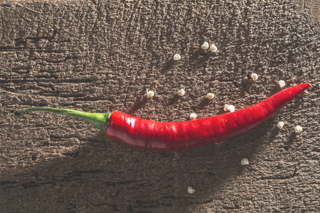 Hot peppers on wooden kitchen cutting board.の写真素材