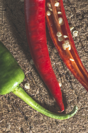 Hot peppers on wooden kitchen cutting board.の写真素材