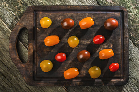 Variety of cherry tomatoes on wood. Multicolored tomatoesの写真素材