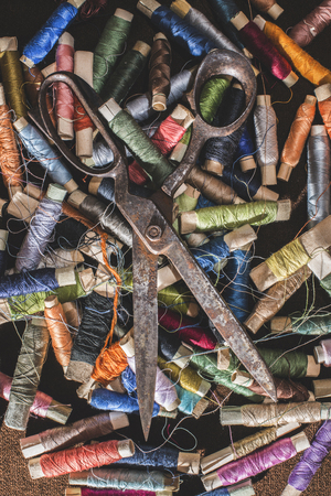 Old vintage scissors on spools of thread. Multicoloredの写真素材