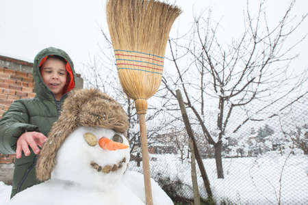 Snowman and child in the yard. Winterの写真素材