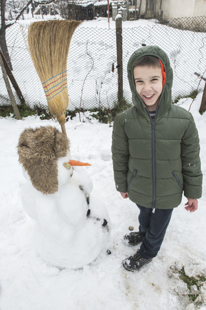 Snowman and child in the yard. Winterの写真素材