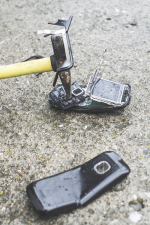Old broken mobile phone. Hammer crease phoneの写真素材