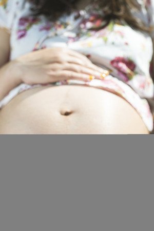 Pregnant women hold picture of womb. Daylight in the gardenの写真素材