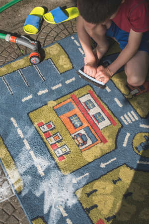 Child clean carpet. Exterior shotの写真素材