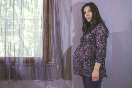 Pregnant women to the window. Violet colorsの写真素材
