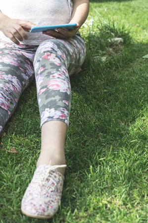 Pregnant women with smartphone in a gardenの写真素材