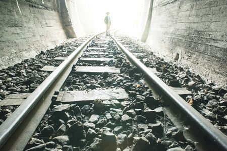Child walking in railway tunnel. Vintage clothesの写真素材