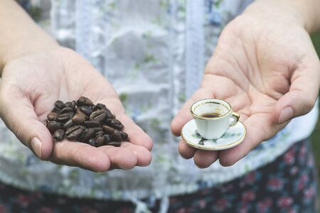Hand hold very small cup of coffee. Miniature cupの写真素材