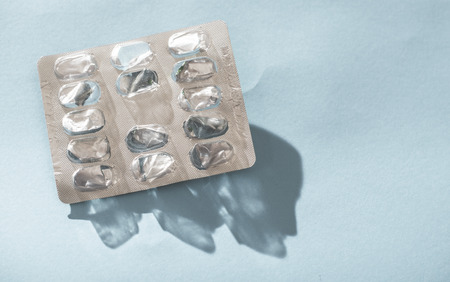 Empty blister pack drugs on blue background