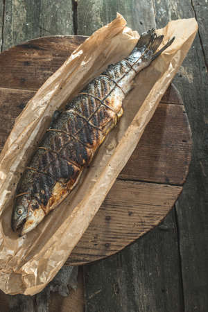 Roasted salmon fish on baking paper. Vintage old wooden tableの写真素材
