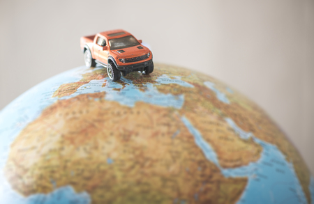 Offroad car on globe. Miniature concept